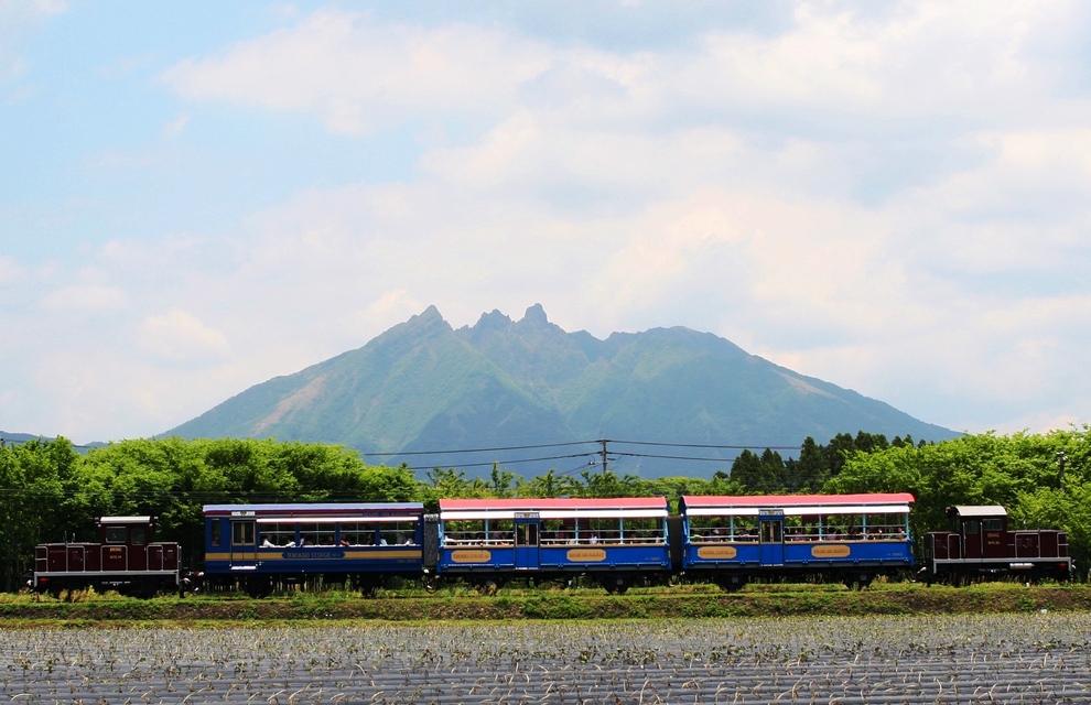 根子岳を背景にトロッコ列車が走っている風景
