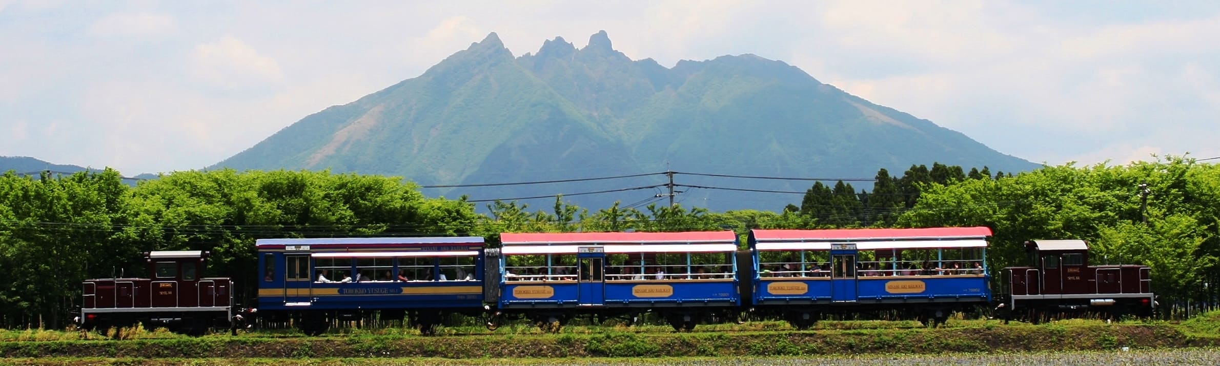 根子岳が背景に写るトロッコ列車の風景