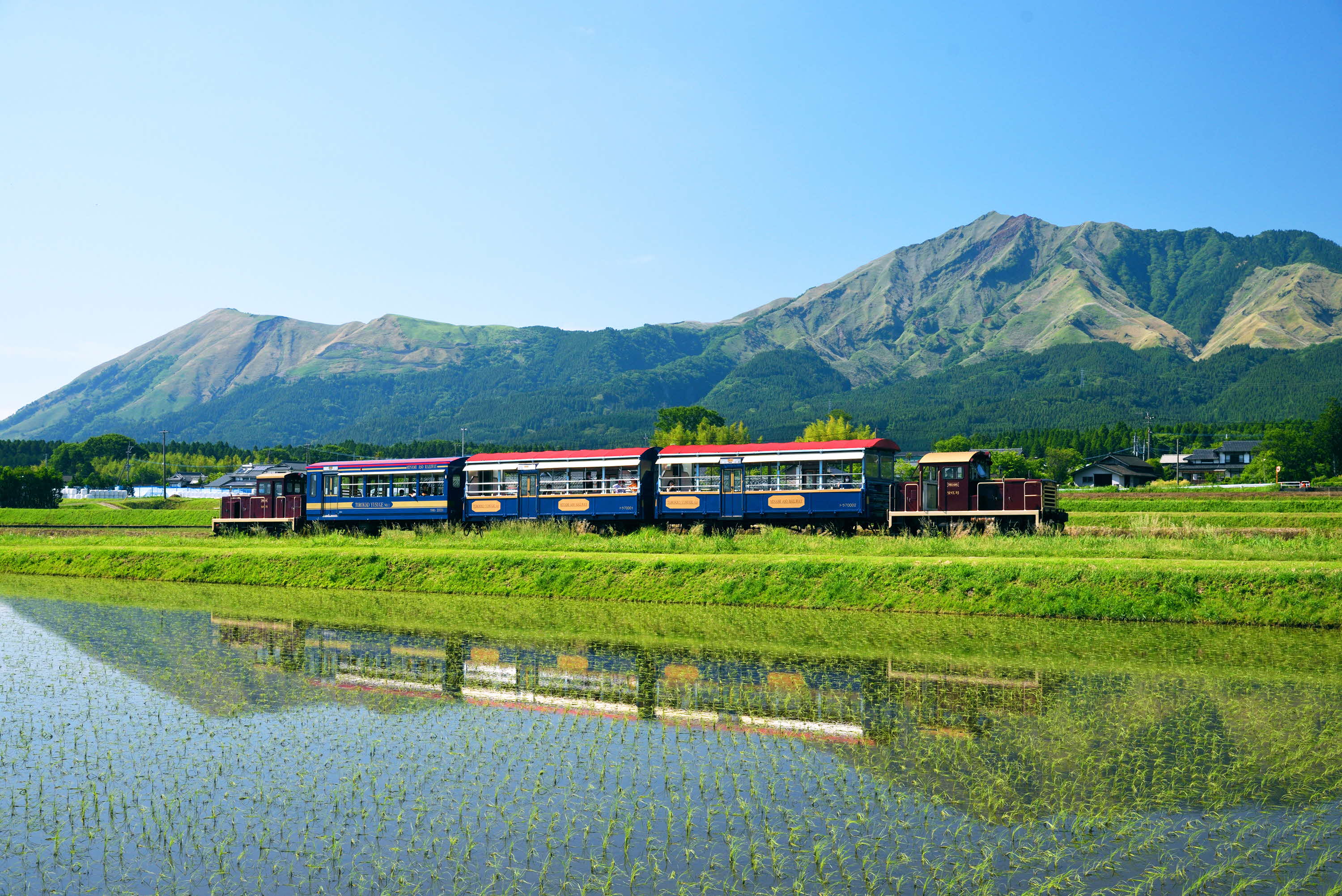 阿蘇五岳が背景に写るトロッコ列車の風景